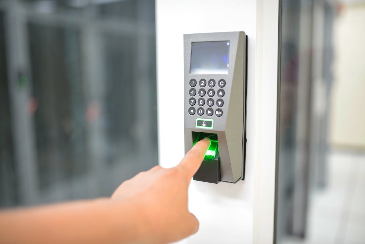 A person uses a fingerprint scanner for secure entry in a business setting.